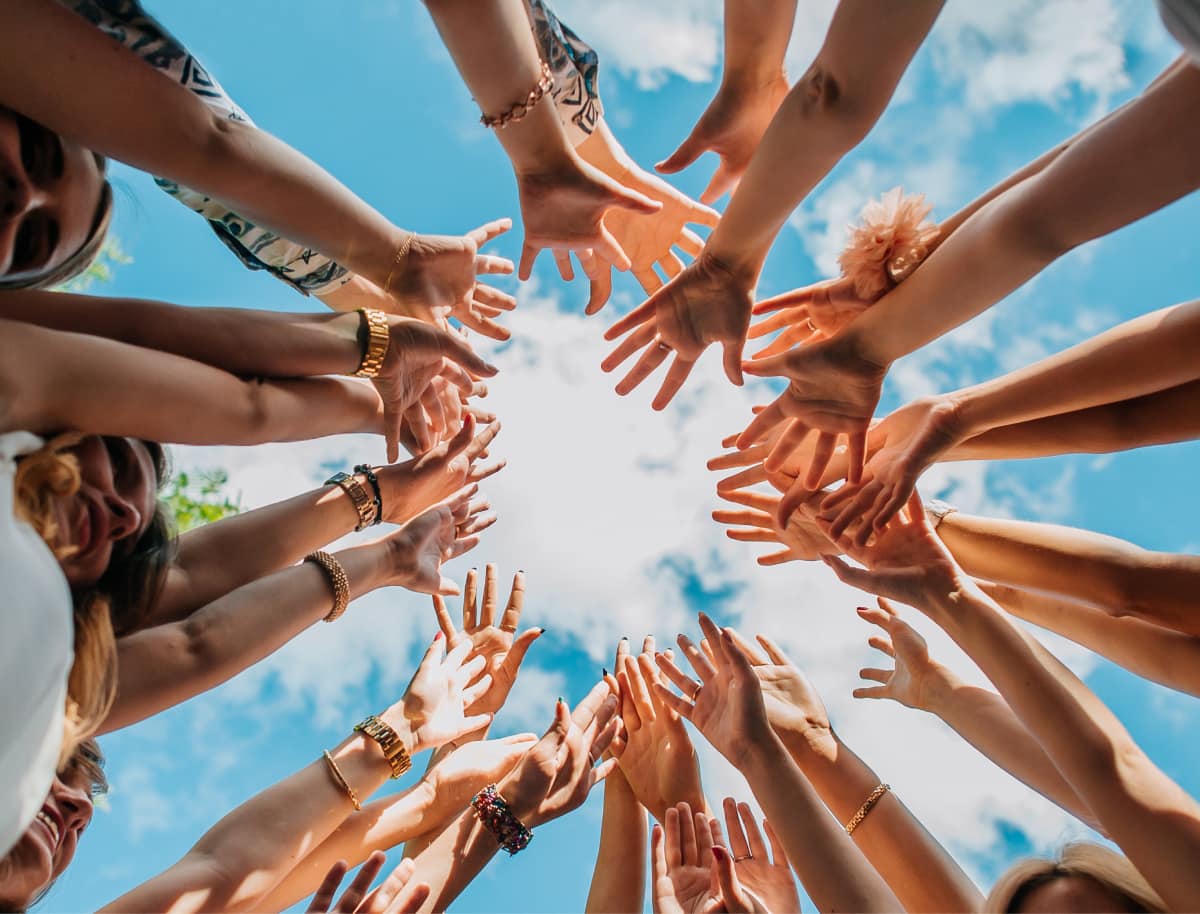 Group of people joining hands and celebrating