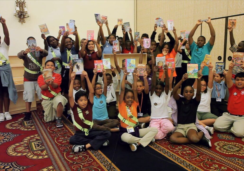 Big group of children holding up books to read